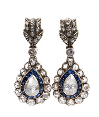 Lot 531 - Pair of antique style diamond and sapphire pendant earrings, each with a pear shaped cluster centred with a rose-cut pear shape diamond surrounded by a border of calibre cut blue sapphires surround...