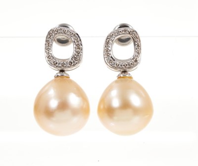 Lot 529 - Pair of cultured pearl and diamond earrings, each with a large cultured pearl of pale gold/champagne tone, measuring approximately 12.5mm-13mm suspended from a diamond set loop in white gold settin...