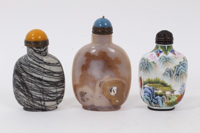 Lot 1032 - Chinese carved agate snuff bottle, of globular form with lapis type cap, 9cm high, together with a banded agate snuff bottle and painted porcelain snuff bottle. (3)