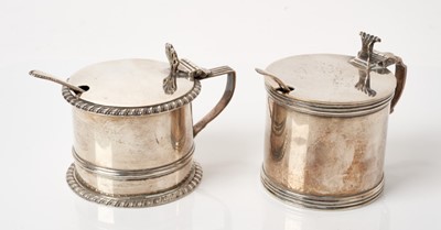 Lot 268 - Georgian-style silver drum-shaped mustard pot with blue glass liner, gadrooned borders,London 1911and another plainer silver mustard pot with blue glass liner, (London 1938)