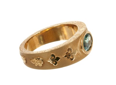 Lot 441 - Large 18ct gold ring with an oval mixed cut green stone in rub-over setting on tapered gold band with applied gold Fleur de Lys and and oak leaves, London 2007. Ring size X.