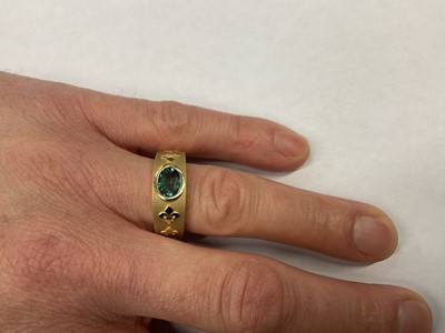Lot 441 - Large 18ct gold ring with an oval mixed cut green stone in rub-over setting on tapered gold band with applied gold Fleur de Lys and and oak leaves, London 2007. Ring size X.