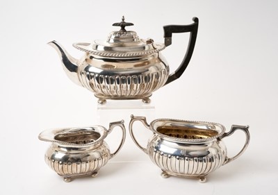 Lot 287 - Edwardian Georgian-style silver fluted three piece tea set with gadrooned borders  on bun feet, Walker and Hall (Sheffield 1908), 43ozs all at