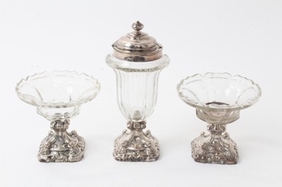 Lot 298 - Pair 19th century Continental silver mounted and cut glass salts of pedestal form and matching mustard pot on rococo scroll bases (3)