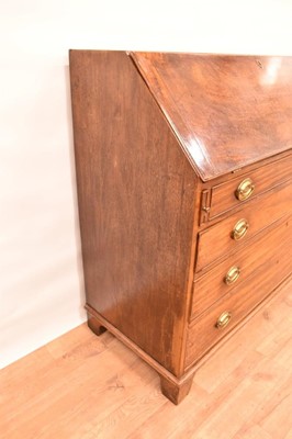 Lot 1401 - George III mahogany bureau, the well fitted interior with drawers, pigeon holes and secret compartments about central inlaid cupboard door, having four long graduated drawers below on bracket feet,...