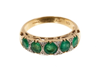 Lot 485 - Emerald five stone ring with five graduated round mixed cut emeralds with diamond accents to the claws in 18ct gold setting, ring size N.