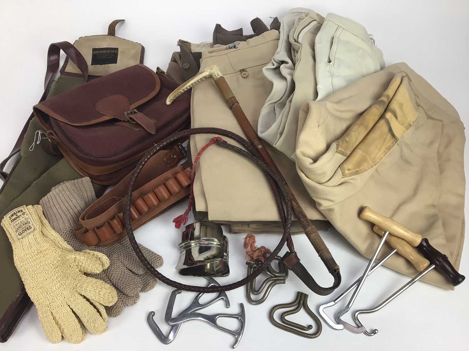 Lot 923 - Six pairs of riding breeches including two 1950s pairs, pair of Swaine & Adeney hunting gloves, another pair, four white stocks, hunting whip, assorted boot pulls, cartridge bag, belt and gun sling