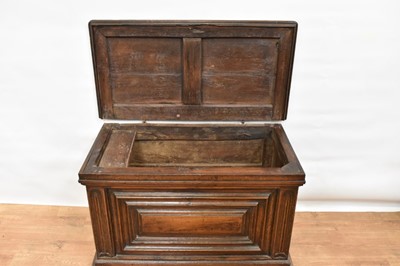 Lot 1466 - 17th century Continental oak cassone, of small size, with hinged lid and interior candle box, panelled front flanked by iron carrying handles, on stiles