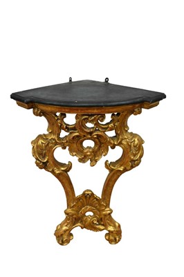 Lot 1473 - 18th century and later carved giltwood corner console table, with shaped painted wooden top of C-scroll rococo pierced gilt support, approximately 70cm wide x 50cm deep x 87cm high