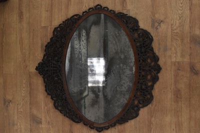 Lot 1488 - Fine 18th century Colonial hardwood wall mirror, with pleasantly distressed oval plate in cushion frame with ornate pierced surround, 77 x 78cm