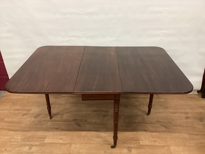 Lot 1445 - Early 19th century mahogany drop leaf dining table, rounded rectangular hinged top with reeded edge, on turned legs amd castors, 152cm x 106cm x 73cm high