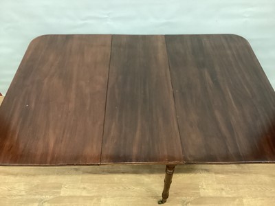 Lot 1445 - Early 19th century mahogany drop leaf dining table, rounded rectangular hinged top with reeded edge, on turned legs amd castors, 152cm x 106cm x 73cm high