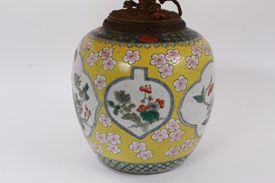 Lot 130 - Chinese famille jaune porcelain jar, decorated with panels containing flowers, insects and a peacock, on a yellow ground with prunus blossom, Qianlong seal mark to base but 19th century, converted...