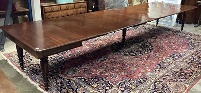 Lot 1446 - Very large 19th century and later mahogany extending dining table, with rounded rectangular pull-out top raised on lappet carved legs and castors, with six additional leaves, 125 x 122cm extending...