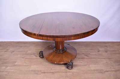 Lot 1448 - William IV rosewood circular breakfast table, with circular tilt top, on inverted tapered column on circular base with projecting rosette carved feet and castors, 121cm diameter