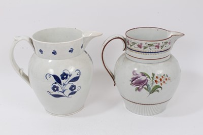 Lot 138 - Two early 19th century pearlware pottery jugs, both decorated with floral patterns, one in polychrome enamels and the other blue and white, 22cm high