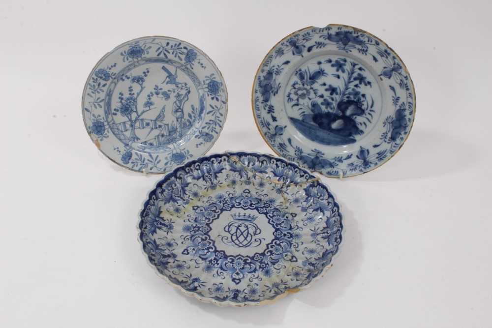 Lot 140 - Three 18th century delftware plates, including one English and painted with a Chinese figure in a garden, one Dutch with central monogram, and another Dutch with flowers in the Chinese style