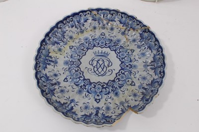 Lot 140 - Three 18th century delftware plates, including one English and painted with a Chinese figure in a garden, one Dutch with central monogram, and another Dutch with flowers in the Chinese style