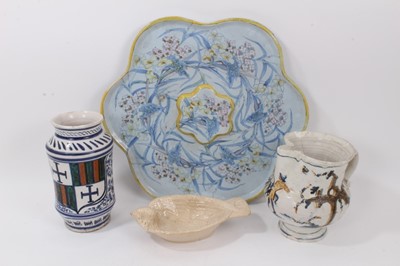 Lot 144 - A group of continental ceramics, including a large polychrome faience dish of flower form, a faience jug, an albarello and a bird-form bowl (4)