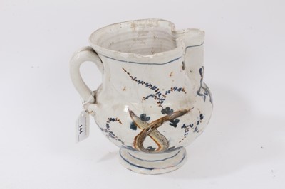 Lot 144 - A group of continental ceramics, including a large polychrome faience dish of flower form, a faience jug, an albarello and a bird-form bowl (4)