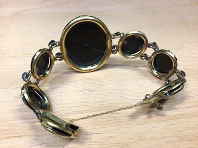 Lot 31 - Victorian black glass cameo bracelet in yellow metal setting together with a black onyx and silver brooch (2)