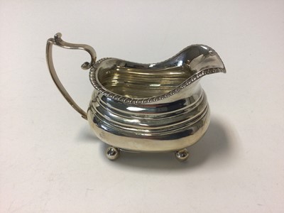 Lot 112 - Regency silver cream jug, with ribbed body, gadrooned edge and ball feet, 14cm from spout to handle, London 1818, 6.1oz