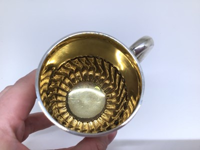 Lot 140 - Edwardian gilt-lined silver mug, of cylindrical form with fluting to the bottom half, loop handle, 8cm high, London 1902 (William Hutton & Sons), 4.5oz