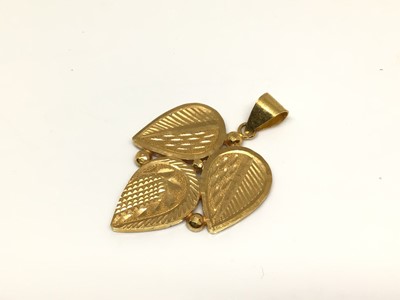 Lot 161 - Eastern yellow metal (stamped S22K) three leaf pendant with engraved geometric decoration, 4.8cm long