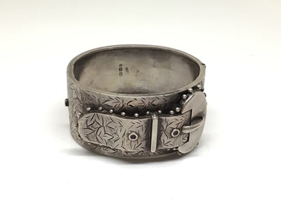 Lot 197 - Victorian silver hinged bangle with applied buckle and engraved foliate decoration