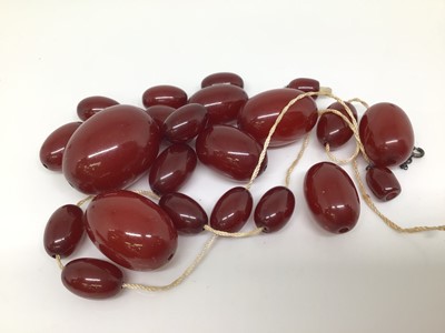 Lot 1026 - Two vintage simulated cherry amber bead necklaces (all loose)