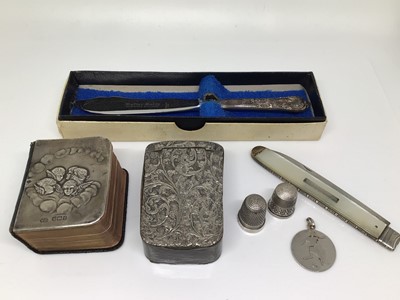 Lot 1028 - Silver mounted miniature Common Prayer book, two silver thimbles, silver football fob, silver and mother of pearl fruit knife, butter knife and a snuff box