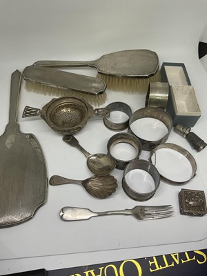 Lot 1078 - Group of silver to include a tea strainer, hand mirror, napkin rings etc