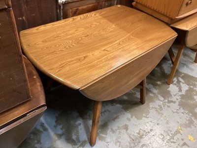 Lot 1289 - Ercol drop leaf dining table on splayed legs joined by X frame stretchers, 112cm x 183cm together with a set of four Ercol chairs