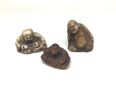 Lot 424 - Carved wood netsuke of a seated man making a mask, character mark to base, and two other small resin figures (3)