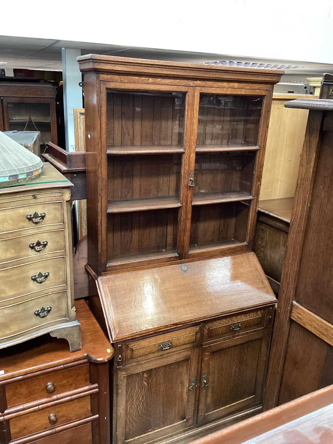 Lot 1319 - Edwardian oak two height bureau bookcase with shelves above enclosed by two glazed doors, writing slope, two drawers and two panelled doors below, 108cm wide, 45cm deep, 213cm high