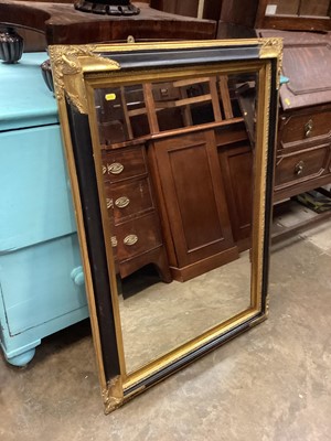 Lot 1338 - Bevelled wall mirror in gilt and black frame, 79cm x 110cm