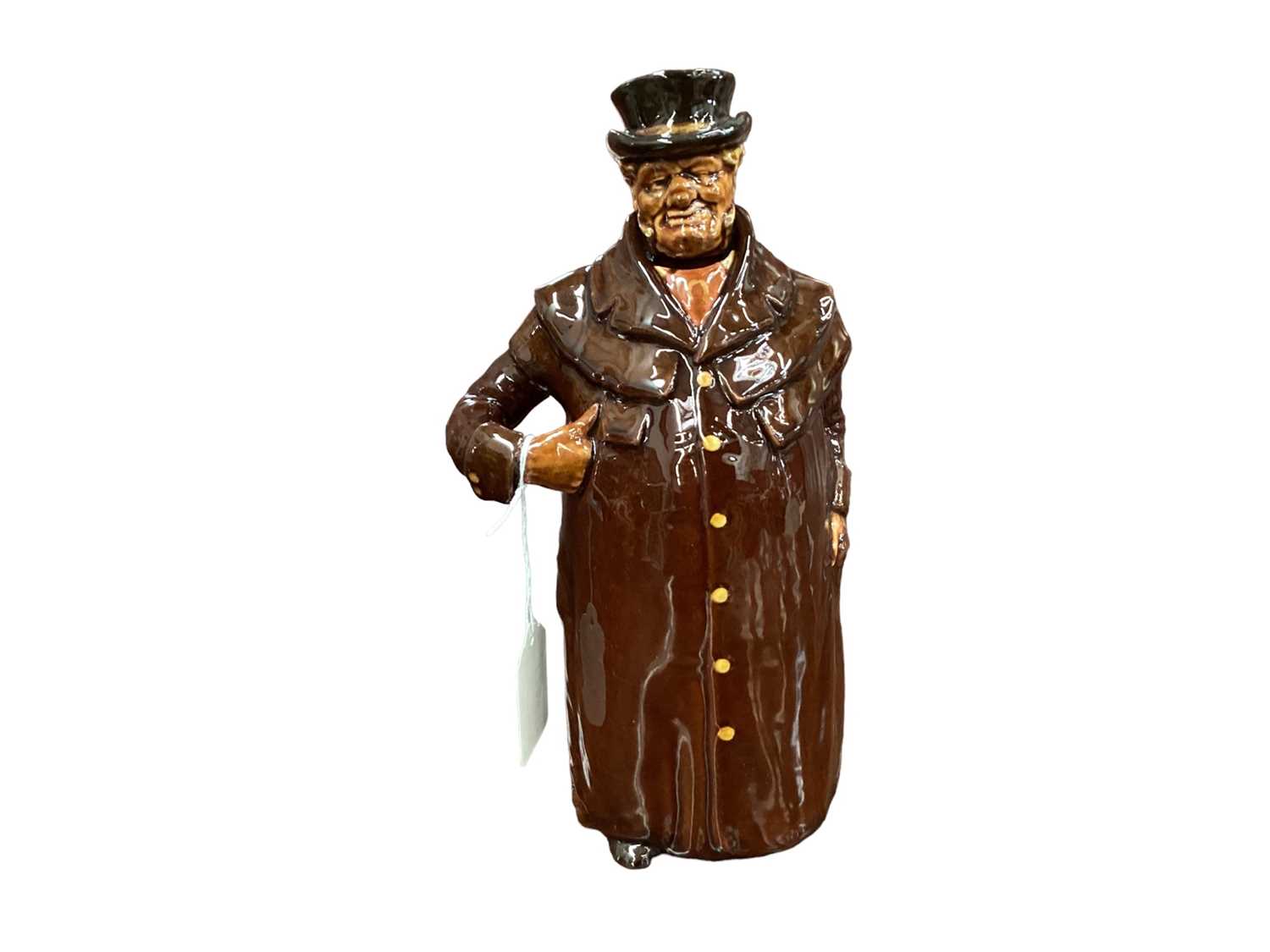 Lot 1142 - Royal Doulton Kingsware miniature figural whisky jug, Coachman, modelled as a man with hand in pocket, the arm forming the handle, removable head stopper, 14.5cm high