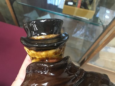 Lot 1142 - Royal Doulton Kingsware miniature figural whisky jug, Coachman, modelled as a man with hand in pocket, the arm forming the handle, removable head stopper, 14.5cm high