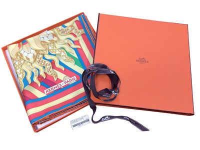 Lot 2153 - Hermès silk scarf Les Sangles De Phoebus designer J Metz, in orange Hèrmes box and with brown ribbon.