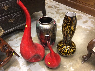 Lot 717 - Glazed studio pottery vase, 46 cm high and two tone brown art glass vase, 57 cm high, plus two red swan neck vases