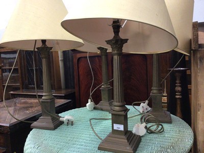 Lot 721 - Four matching brass Corinthian column style table lamps and shades