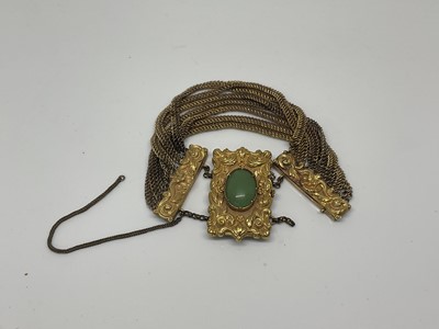 Lot 1059 - Regency gilt metal bracelet with green cabochon clasp and multi-strands.