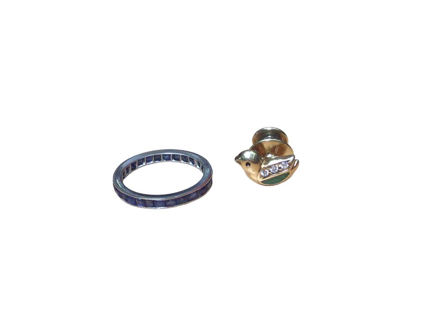 Lot 56 - Platinum and blue sapphire eternity ring and a gold (750) enamel and paste set novelty pin in the form of a duck (2)
