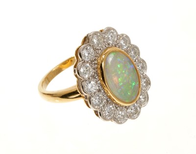 Lot 635 - Opal and diamond cluster ring with an oval opal cabochon weighing 1.96ct surrounded by a border of brilliant cut diamonds weighing 1.45ct in total. In 18ct gold