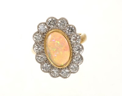 Lot 635 - Opal and diamond cluster ring with an oval opal cabochon weighing 1.96ct surrounded by a border of brilliant cut diamonds weighing 1.45ct in total. In 18ct gold