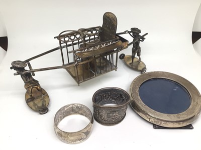 Lot 1140 - Chinese silver plated cruet holder in the form of two figures carrying a sedan chair, together with two white metal napkin rings and a round silver photograph frame