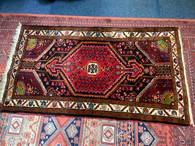 Lot 1503 - Eastern rug with central medallion on red, brown, cream and black ground, 136cm x 79cm