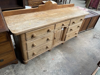 Lot 13 - Antique pine dresser base with seven drawers about the recessed cupboard on bun feet, 181w x 55d x 91h