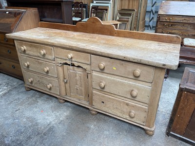 Lot 13 - Antique pine dresser base with seven drawers about the recessed cupboard on bun feet, 181w x 55d x 91h