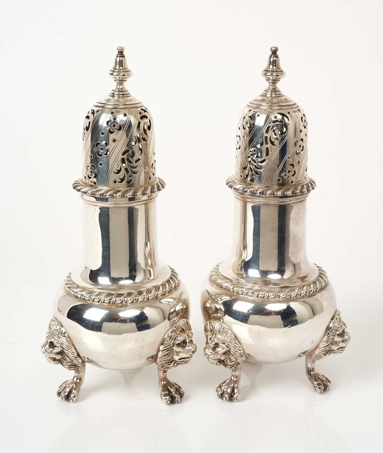 Lot 478 - Pair of 1930s silver sugar casters of baluster form on three lion mask and claw feet